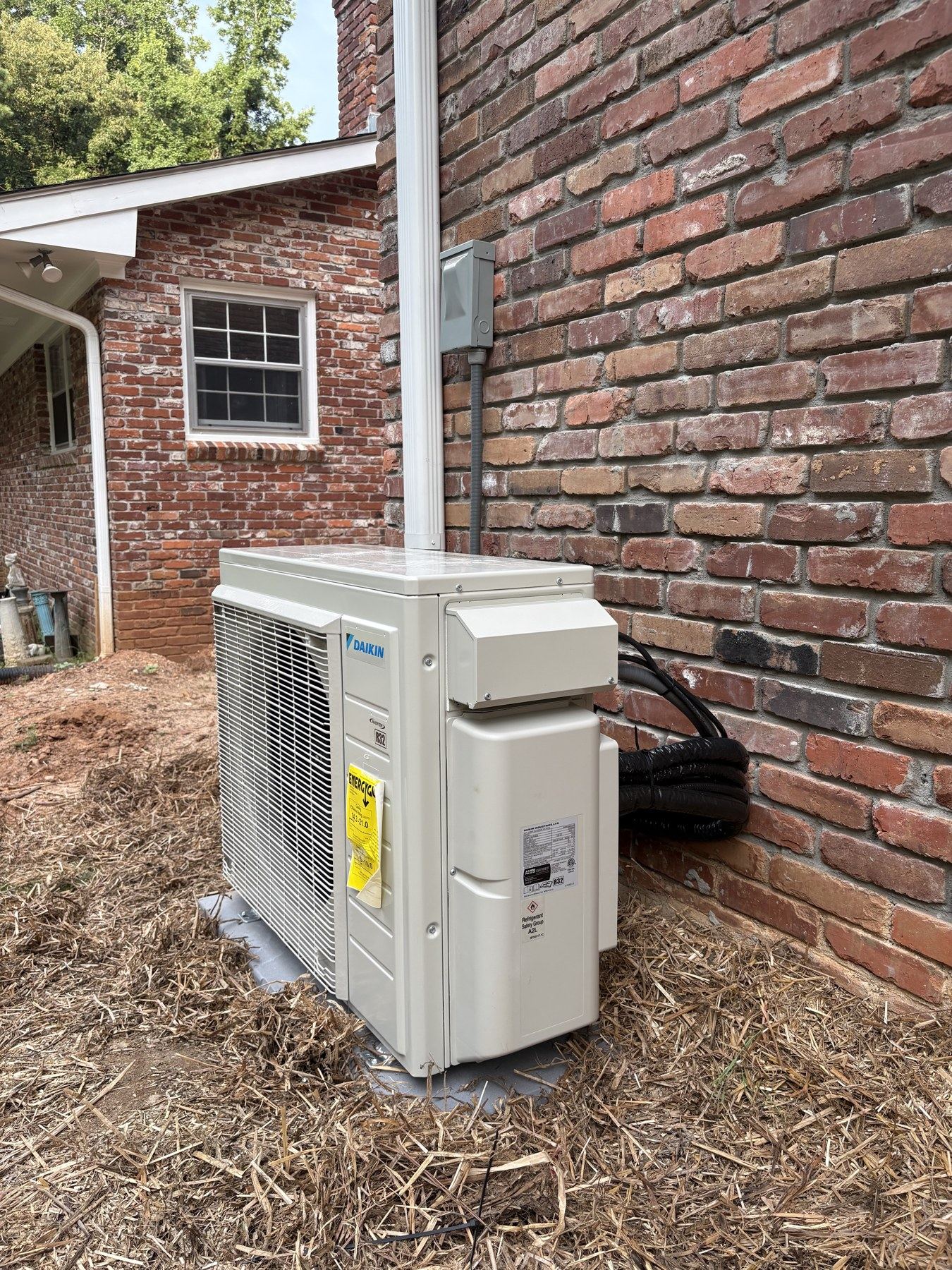 Outdoor unit installed beside a brick home